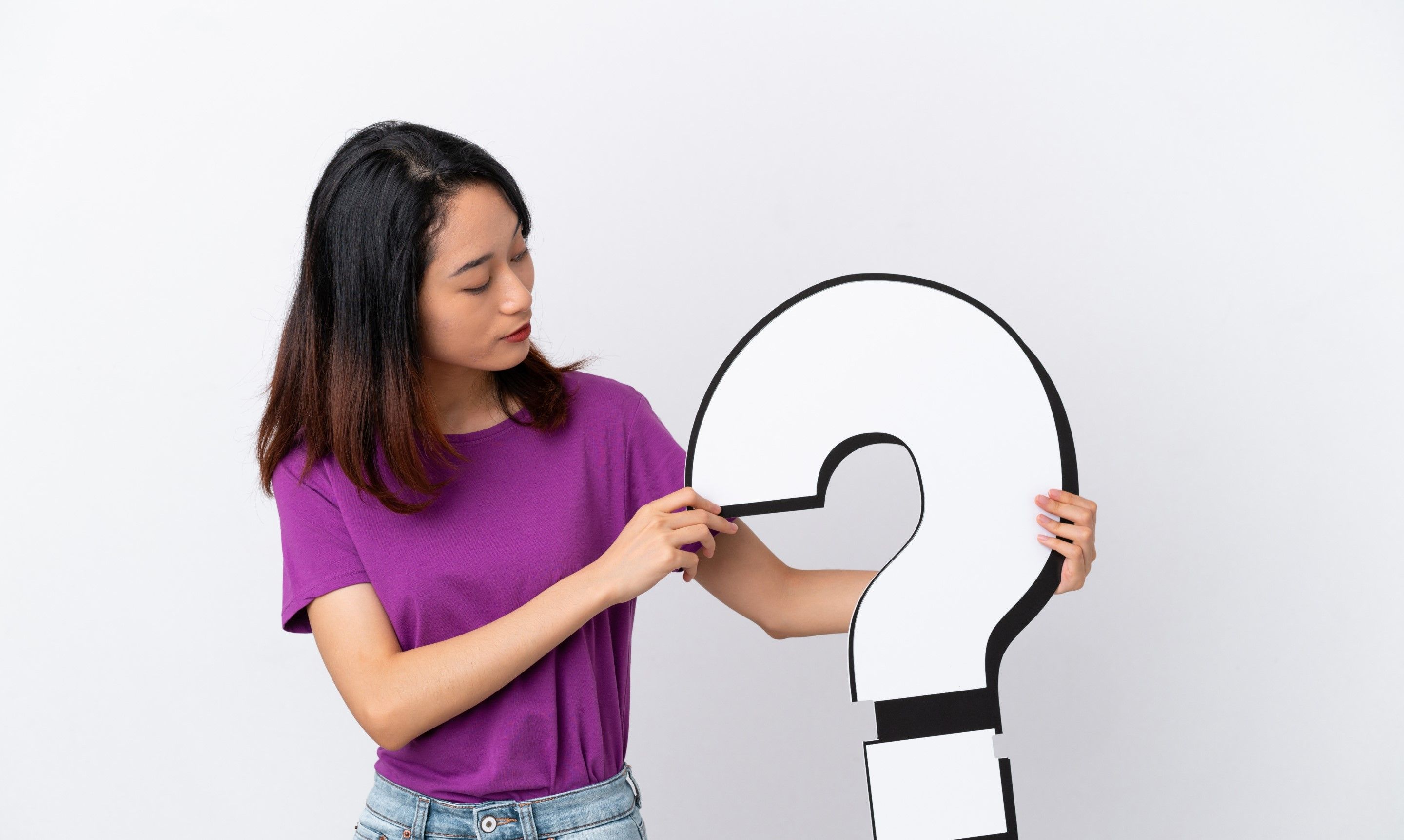 woman holding a question-mark-shaped prop